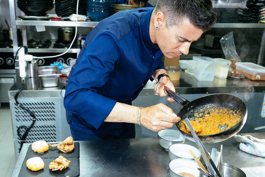 Chef cooking sauce in pan plating food