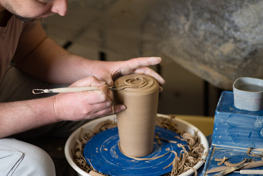 Male hands working with clay on a potter's wheel
