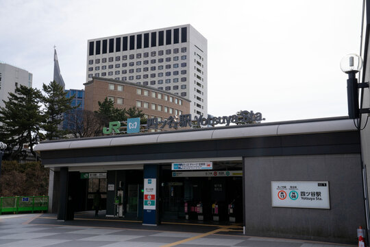 JR線と東京メトロのロゴ看板が掲げられた、モダンな四ツ谷駅の出入り口と高層ビル風景