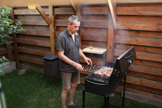 A man is preparing food on the grill.