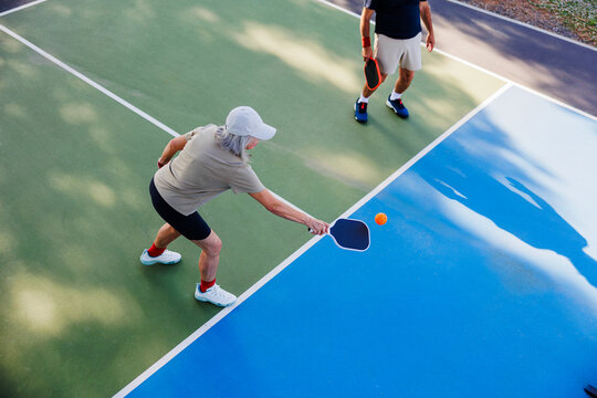 Senior couple enjoying active pickleball game outdoors