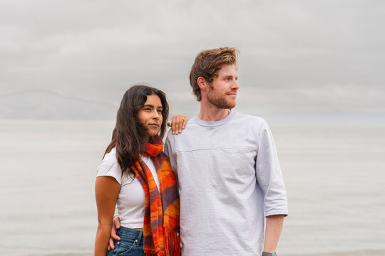 casual stylish serious couple standing together looking at horizon 