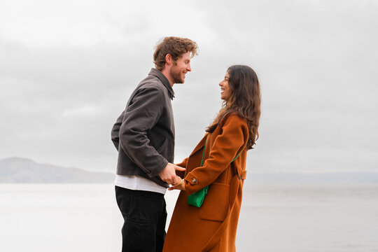 fun couple holding each other looking at each other lovingly smile