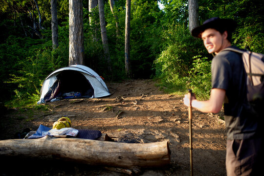Hiker Walks Near a Campsite in the Forest During the Day