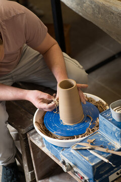 Male hands working with clay on a potter's wheel