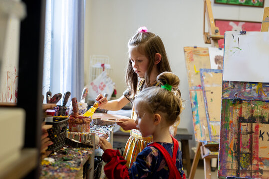 Children in art school work with paints