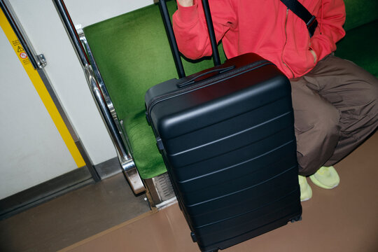 Suitcase Beside Passenger on Train