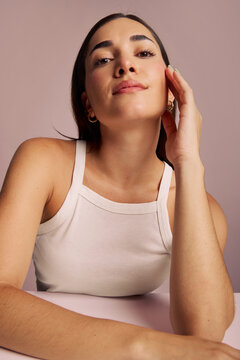 Model Poses With Hand on Face in Studio