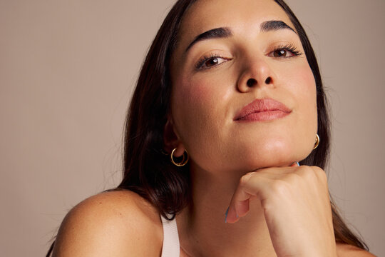 Woman Posing With a Hand on Her Chin in a Studio Setting