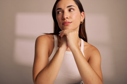 Woman Thinking With Hands Under Chin in a Bright Room