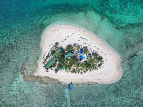 Aerial view of South Sea Island with white sand beaches, turquoise coral reef waters, and resort facilities in Western Division, Fiji.