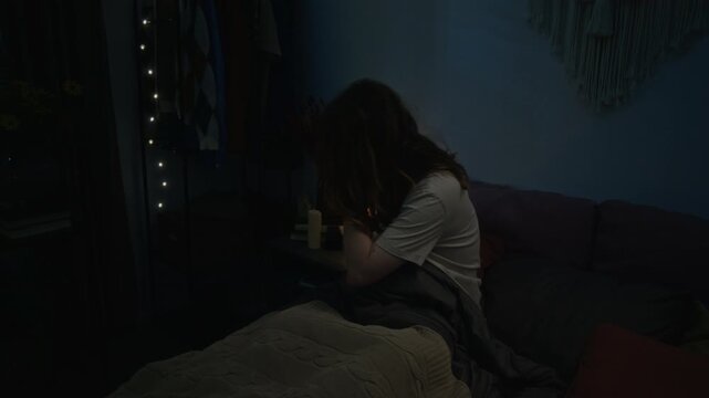 Young Caucasian woman waking up suddenly in bed from nightmare, rubbing temples in distress. Footage is suitable for mental health awareness campaigns and sleep disorder advertisements