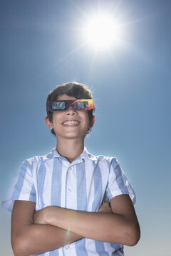 Smiling Boy Wearing Solar Eclipse Glasses Under the Sun