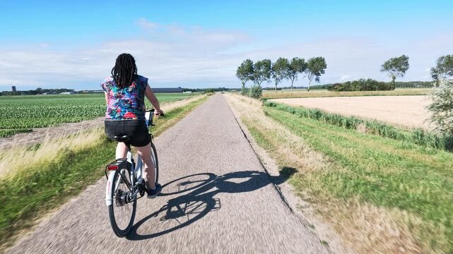Woman cycling through Dutch countryside
