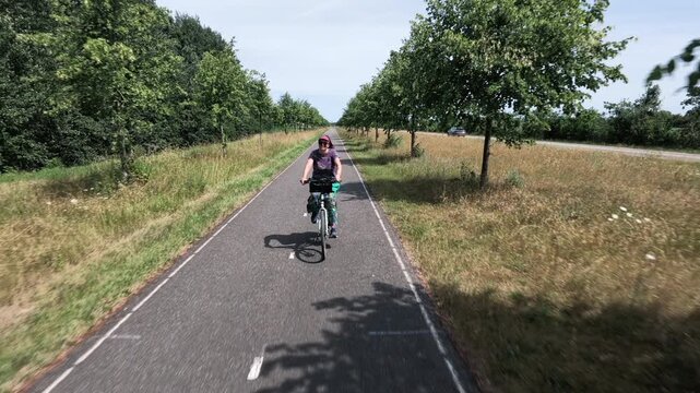 Woman cycling through Dutch countryside
