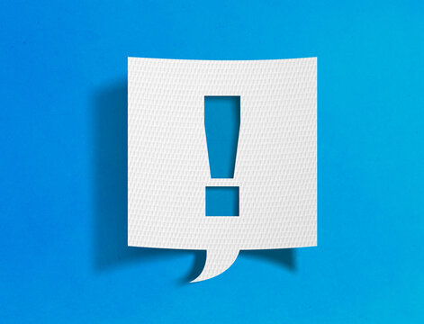 Exclamation mark speech bubble on blue background with paper cutout design