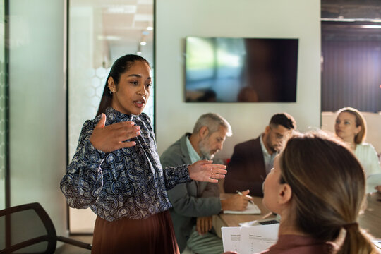 Young businesswoman leading team discussion in modern office