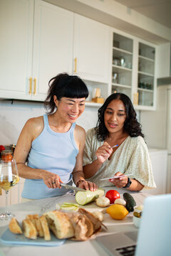 Two women cooking together in modern home kitchen