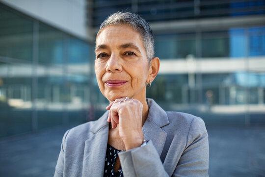 Confident senior businesswoman portrait outside modern office