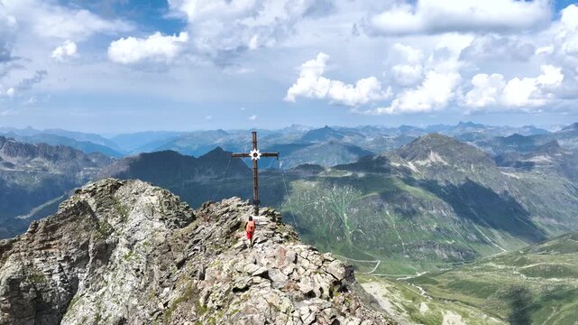 Aerial view of a hiker walking to the summit cross of Hohes Rad in Montafon, Alps of Austria