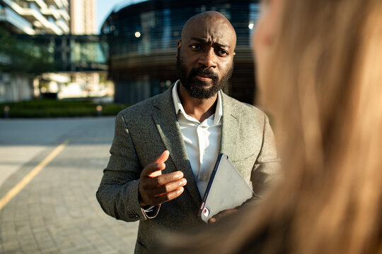 Business professional discussing project outside city office