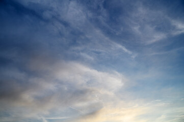 Obraz premium Atmospheric Clouds at Twilight with Deep Blue and Warm Golden Sky