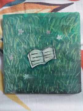 An artistic hand paint illustration featuring an open book resting on a lush green meadow