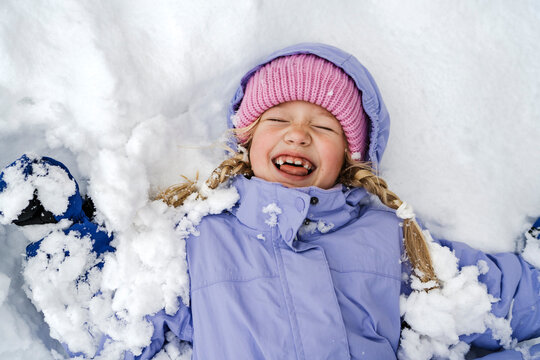 A happy girl enjoys the winter snow outdoors
