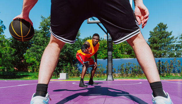 Male athlete dribbles a basketball against an opponent on the court