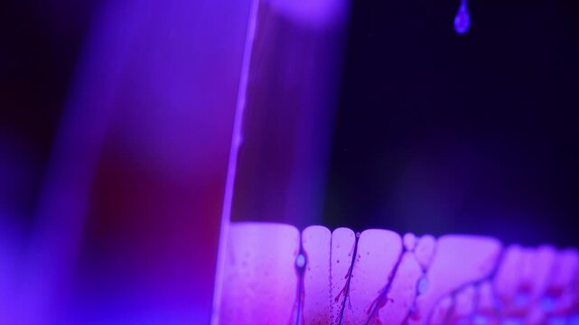 Glowing violet fluid boundary with intricate dark marble waveforms. Intense violet backlight illuminates a sharp diagonal liquid plane boundary.
