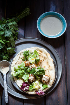 Homemade falafel with salad, tahini sauce on flat bread