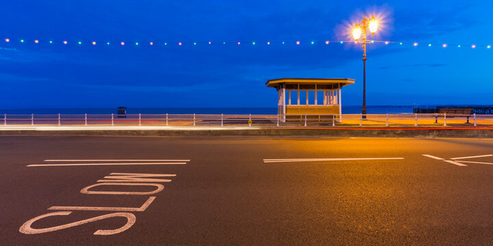 Empty seafront road and tram shelter at night in Southsea