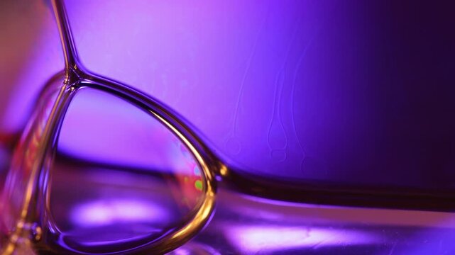 Glowing violet foam vertex with golden specular film boundaries. Crisp geometric film boundaries converge into an intricate fluid node in low-key macro perspective