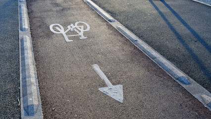 Fototapeta premium Bicycle lane symbol, arrow, asphalt, bike path marking