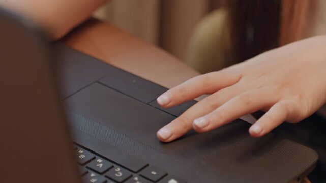 Person working with laptop device. Individual typing and exploring information online. Closeup image depicting hands maneuvering notebook computer during study and research activities