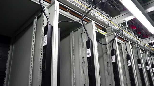 Handheld Pan Across Empty Server Cabinets in Modern Data Center with Ceiling Cable Infrastructure