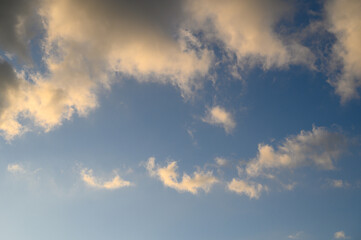 Obraz premium Cloud landscape clear blue sky with golden and white clouds illuminated by sunlight creating calm