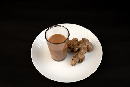 Traditional Indian ginger tea in a clear glass isolated on a black background