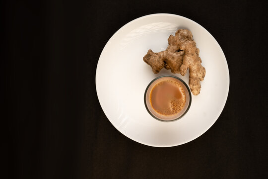 Traditional Indian ginger tea in a clear glass isolated on a black background