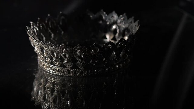 Luxury white gold Crown with Mirror Reflection on Dark Gray Background. Royal Elegance. 4K. Cinematic lighting enhances crystal brilliance and symmetrical reflections
