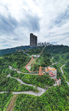 Aerial view of Genting Highlands resort with the Chin Swee Caves Temple, winding roads, and high-rise buildings surrounded by lush tropical forest in Genting Highlands, Pahang, Malaysia.
