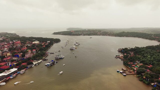 Casino boats and ferries on the Mandovi river winding past green shores - July, 2026, Panaji, India
