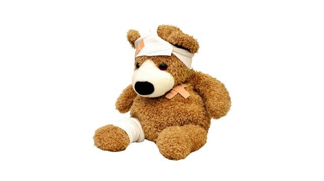 Injured brown teddy bear sitting with bandages and medical tape childhood accident isolated background hospital recovery treatment wellness bandaged teddybear