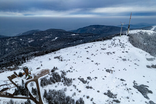 Aerial view of the snow-covered Hornisgrinde summit with wind turbines and the Bismarck tower in the Black Forest, Seebach, Baden-Wurttemberg, Germany.