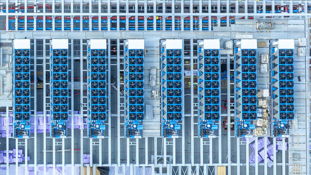 Aerial view of Portus Data Centers - Munich featuring rows of industrial cooling fans and HVAC units installed on the rooftop structure in Kirchheim bei Muenchen, Bavaria, Germany.