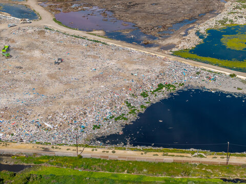 Aerial view of a large landfill site with piles of waste, dark water pools, and dirt roads in Vredenburg, Western Cape, South Africa.