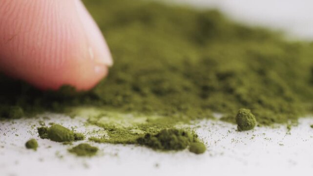 Green chlorella algae powder on a wooden spoon, top view. Healthy nutritional supplement.