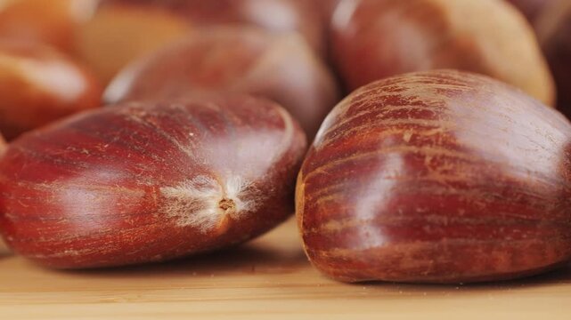 Fresh chestnut, supermarket food, Oven roasted chestnuts with sliced peel on wooden board, spanish traditional winter dish.
