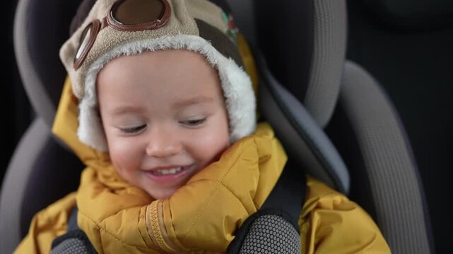 A young child in a car seat. Child, baby, chair, car, winter, rides, sits, kid. A kid lifestyle sits on a snowy ride in winter.