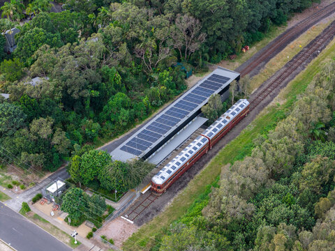 Aerial view of the world's first solar power train at the station surrounded by lush greenery and trees in Byron Bay, New South Wales, Australia.
